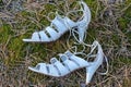 two white leather sandals shoes lie on the gray ground on the street lie on the ground Royalty Free Stock Photo