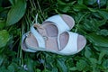 Two white leather sandals stand on green grass Royalty Free Stock Photo