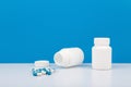 Two white medication bottles with spilled pills. Concept of healthcare and medical treatment Royalty Free Stock Photo