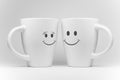 Two white mugs with facial expressions