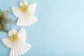 Two white paper angels on blue background. Christmas concept. Top view, flat lay, copy space