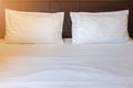 Two white pillows with white bedding sheet on empty bed in bedroom Royalty Free Stock Photo