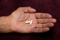 Two white pills in old men`s hands . Painful old age. Health care of older people Royalty Free Stock Photo