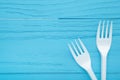 Two white plastic forks on a blue wooden background Royalty Free Stock Photo