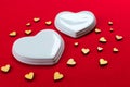 Two white porcelain hearts and many small hearts on a red background.