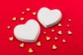 Two white porcelain hearts and many small hearts on a red background.