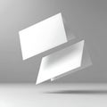 Two white rectangular cards floating in the air against a gray background in a studio setting Royalty Free Stock Photo