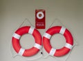 Two white red lifebuoy hanging on grey background. concept rescue equipment and safety Royalty Free Stock Photo