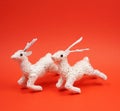 Two white reindeer decoration at red background with copy space for your own text