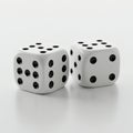 Two white six-sided dice with black dots are positioned against a plain white Royalty Free Stock Photo