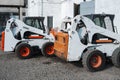 Two white skid steer loader at a construction site waiting of work. Industrial machinery. Industry. Royalty Free Stock Photo