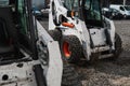 Two white skid steer loader at a construction site waiting of work. Industrial machinery. Industry. Royalty Free Stock Photo