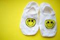 Two white socks with a happy smiley face on a yellow table Royalty Free Stock Photo