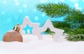 Two white star lanterns and Christmas tree toy on the snow with fir branches. On blue background, snowflakes and bokeh Royalty Free Stock Photo