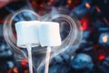 Two white sweet marshmallows roasting over fire flames. Smoke in form of heart. Marshmallow on skewers roasted on Royalty Free Stock Photo