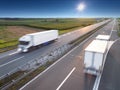 Two white trucks on highway at sunny day Royalty Free Stock Photo