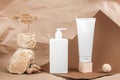 Two white tube, bottle with cream, moisturizing lotion, shampoo or other cosmetic product and stones, wooden geometric shapes, Royalty Free Stock Photo