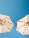 Two White Umbrellas Against a Blue Sky