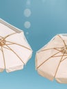 Two White Umbrellas Against a Blue Sky