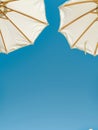 Two White Umbrellas on Sandy Beach