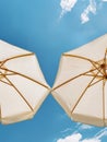 Two White Umbrellas on Sandy Beach