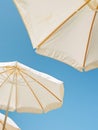 Two White Umbrellas on Sandy Beach