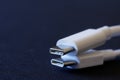 Two white usb type-c connectors lie on a dark blue background. Close-up. Macro. Bokeh. Free space for an inscription Royalty Free Stock Photo