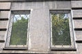 Two white windows with a iron lattice on a gray concrete wall Royalty Free Stock Photo