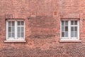 Two white wooden sash windows on a restored red brick wall of a Royalty Free Stock Photo