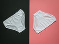 Two white youth panties on a black and pink background. Flat lay