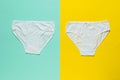 Two white youth panties on a yellow and blue background. Flat lay
