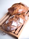 Two whole country breads on a cutting board and white background Royalty Free Stock Photo