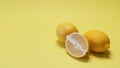 two whole lemons and sliced in half one on yellow background Royalty Free Stock Photo