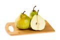 Two whole and one half sliced Green Anjou pears on wooden chopping board, isolated on white background Royalty Free Stock Photo