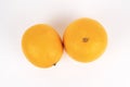 Two whole oranges are positioned near each other on a clean white surface from above Royalty Free Stock Photo