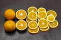Two whole oranges, sliced orange on a brown background Royalty Free Stock Photo