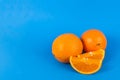 Two whole oranges two orange slices on blue background Royalty Free Stock Photo