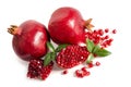 Two whole and part of a pomegranate with pomegranate seeds and leaves Royalty Free Stock Photo