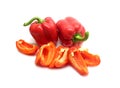 Two whole and sliced red ripe bell peppers on white background close up Royalty Free Stock Photo