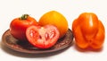 Two whole tomatoes on a clay plate and one half.One tomato is red, the other yellow. Royalty Free Stock Photo