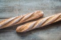 Two wholewheat baguettes on the wooden background