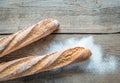 Two wholewheat baguettes on the wooden background