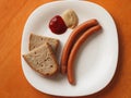 Two wiener sausages with a slice of czech bread