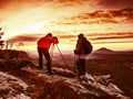 Two wildlife photographers at tripod with set shinning camera