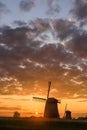 Two Windmills with the sun setting in Netherlands.