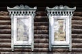 Two windows with carved wooden frames closed by newspapers, traditional Russian rural house in Balashikha, Russia.