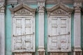 Two windows with closed shutters of an old house with carved decor and stucco, a fragment of the facade Royalty Free Stock Photo