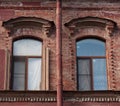 Two windows and drainpipe, on red brick wall Royalty Free Stock Photo