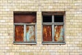 Two windows in the facade of an old abandoned building. Rusty metal sheets in a wooden frame window Royalty Free Stock Photo