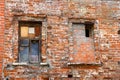 Two windows in an old brick wall, broken red bricks, red brick background Royalty Free Stock Photo